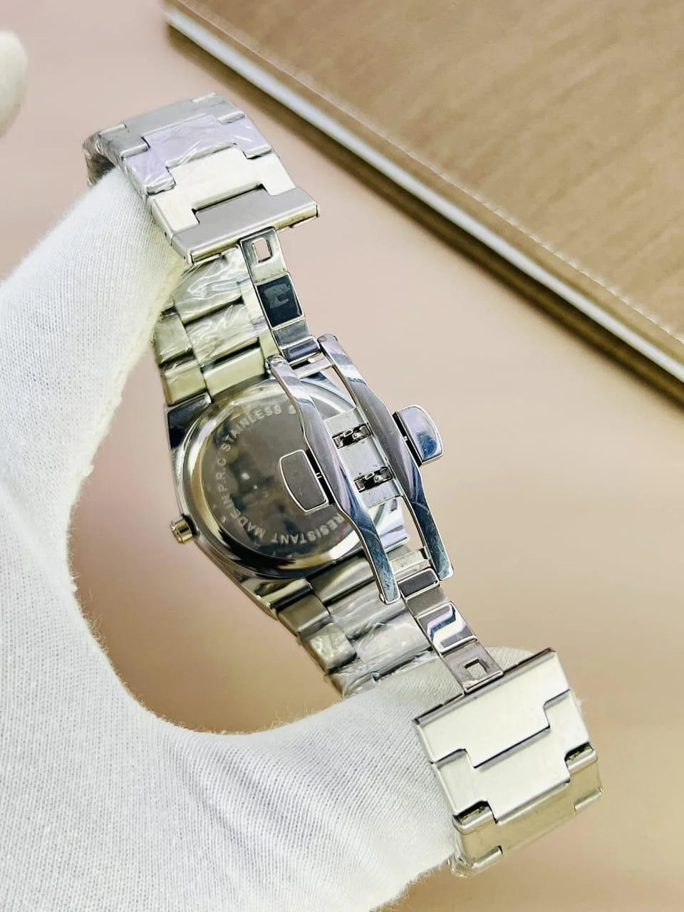 Tissot Prx Chain Watch in Silver White with stainless steel bracelet and textured dial held by gloved hand