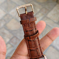 Close-up of brown textured leather strap with gold buckle of tomi t 103 dual strap watch for men