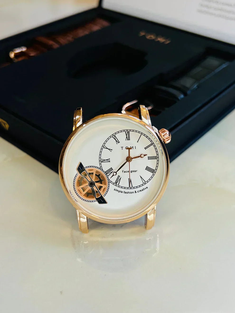 Tomi t 103 dual strap watch for men with white dial and gold-tone case displayed with packaging