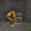 Two classic rings in deal gold and silver bands with polished finish on dark surface