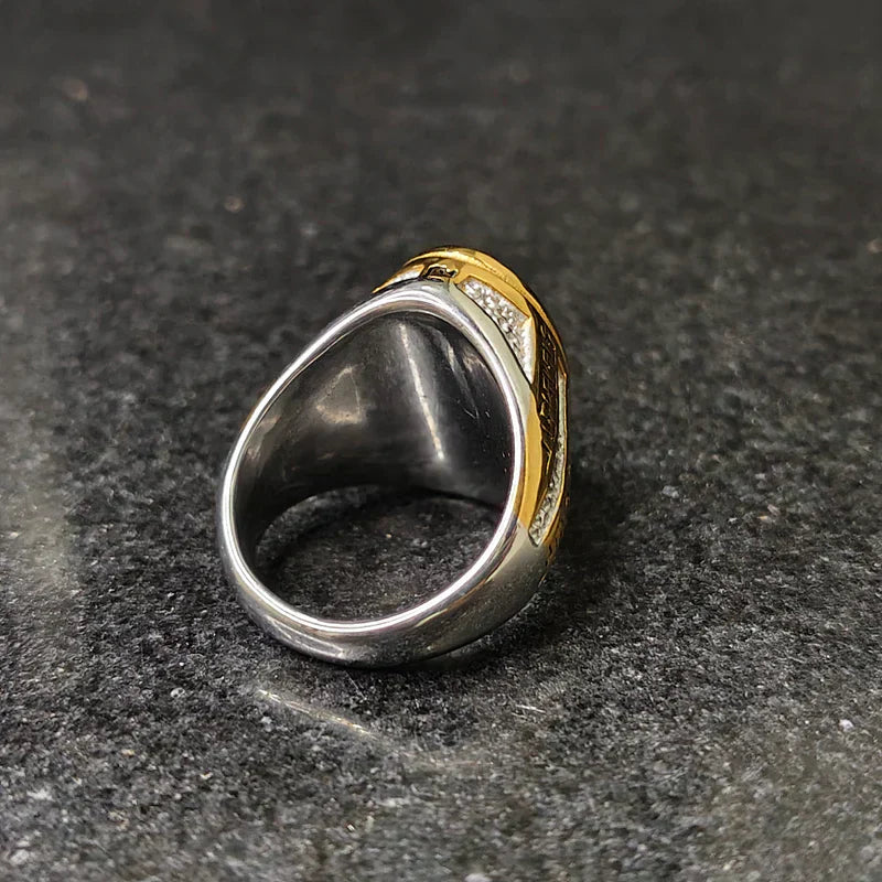 Silver gold oval medusa ring for men with mixed metal design on dark stone surface