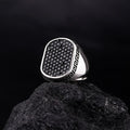 Silver Versace Ring For Men with black stones and Greek key design on band displayed on black rock