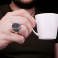Silver Versace Ring For Men with black stone detailing worn on hand holding a white coffee cup